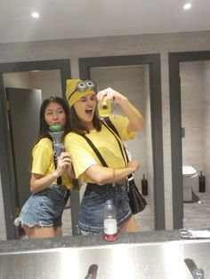 two women in yellow shirts are taking a selfie