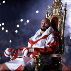 a man sitting on top of a golden throne in front of a crowd at a sporting event