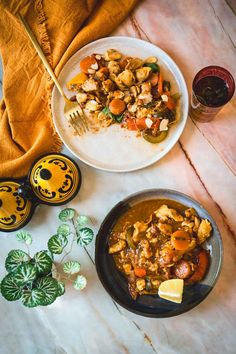 a bowl of stew next to a plate of food