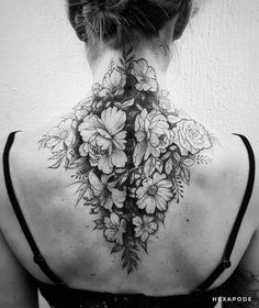 the back of a woman's neck with flowers on it