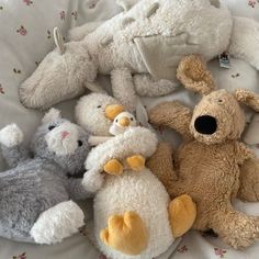 several stuffed animals are laying on a bed