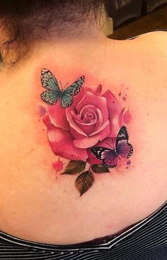 a woman with a pink rose and butterfly tattoo on her back