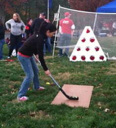 a woman hitting a ball with a bat on top of a wooden box in the grass