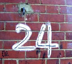 a brick wall with the number twenty four painted on it