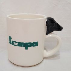 a white coffee mug with a black dog head on it