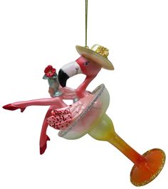 a glass ornament with a pink flamingo wearing a sombrero and hat