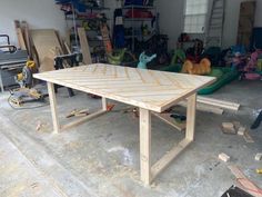 a table being built in a garage with lots of tools on the floor and around it