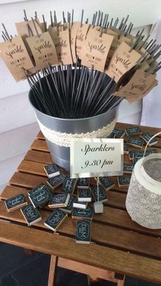 a bucket full of matches sitting on top of a wooden table next to a sign