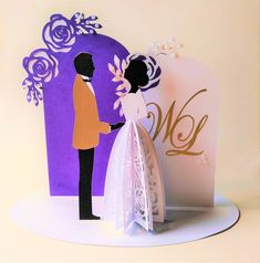 a paper cut out of a bride and groom standing next to each other in front of a purple background