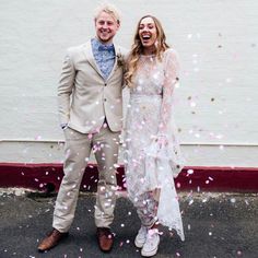 a man and woman standing next to each other in front of confetti