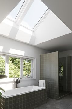 a bathroom with a skylight above the bathtub and shower area is shown in this image