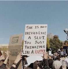 many people holding signs and protesting in front of a statue with a horse on it