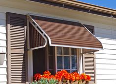 an image of a window with flowers in the windowsills and shutters on both sides