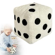 a child is playing with a dice on the floor and it looks like they have been made out of fleeies