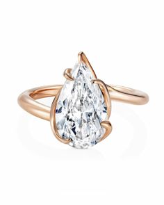 a rose gold ring with a pear shaped diamond in the center and a twisted band around it