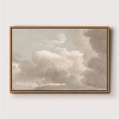 a painting hanging on a wall with clouds in the background