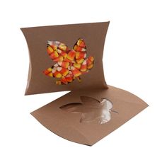 an open box with candy corn in the shape of a butterfly on it's side