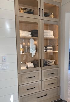 a large wooden cabinet with glass doors and drawers