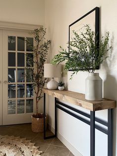 there is a mirror and vases on the mantle in this living room, along with a potted plant