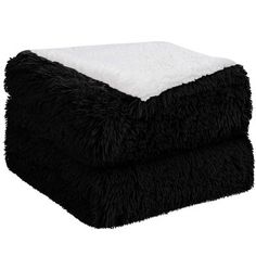 the black and white blanket is folded on top of it's own fluffy material