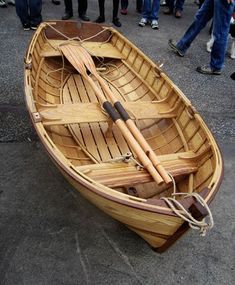 a small wooden boat with oars and paddles