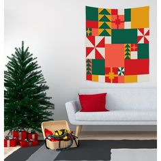 a living room with a couch and christmas decorations on the wall next to a small tree