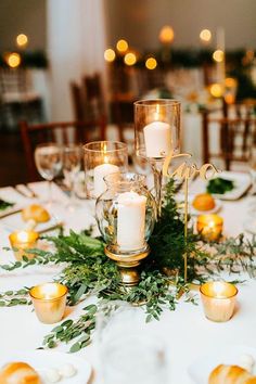 the table is set with candles and greenery