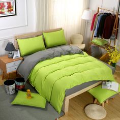 a bed with green sheets and pillows in a room