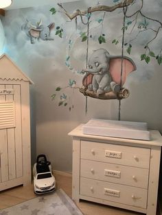 a baby's room with an elephant mural on the wall and a white dresser