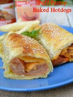 a blue plate topped with two pastries covered in meat and cheese next to french fries