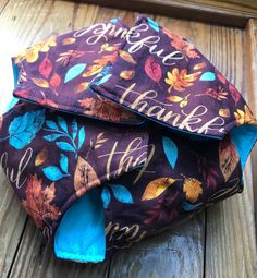 two purple and blue fabric bags sitting on top of a wooden floor next to each other