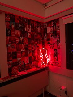 a red neon sign sitting on the side of a wall next to a mirror in a room