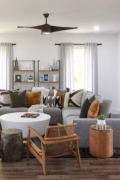 a living room filled with lots of furniture and decor on top of a hard wood floor