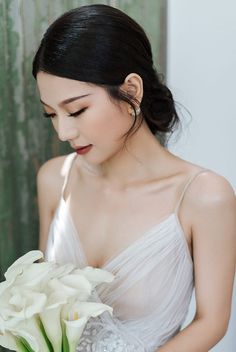 a woman holding a bouquet of flowers in her hands