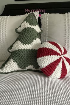 a crocheted christmas tree sitting on top of a bed next to a pillow