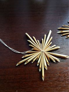 an ornament made out of wood sticks on a wooden table next to a string