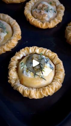 several small pies sitting on top of a black tray