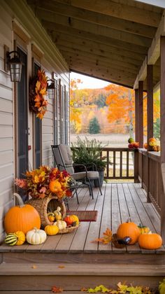 the porch is decorated for fall with pumpkins and gourds on the deck