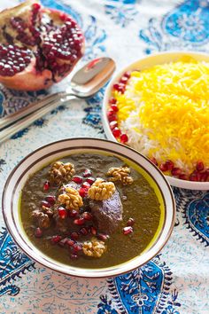 a bowl of soup and a plate of rice with cranberries on the side