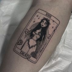 a tattoo on the leg of a woman with a card