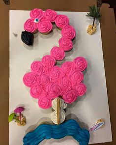 cupcakes are arranged in the shape of a flamingo on top of a piece of paper