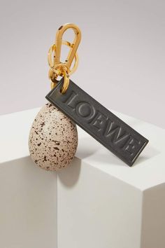 a keychain hanging from the side of a rock with a tag on it