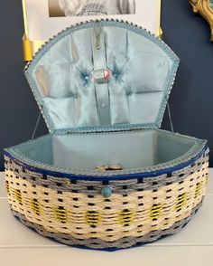 an empty basket sitting on top of a table next to a framed photo in the background