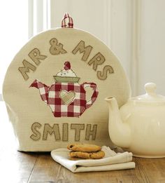 a teapot and cookie on a table with the words mr & mrs smith embroidered onto it