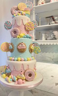 a three tiered cake decorated with candy and lollipops