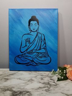 a painting of a buddha sitting on top of a table next to flowers and a vase