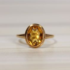 10K Yellow Gold, Citrine Simulant Bezel Set Ring, Size 8 Weight:  2.17 grams Ring Size:  8 Stone Measurements:  9.68 mm x 7.50 mm Shank:  1.56 mm This 10K yellow gold ring features a captivating citrine simulant, expertly bezel set for a sleek, modern look. The oval stone measures 9.68 mm x 7.50 mm, offering a bold yet elegant presence on any hand. With its warm, golden hues, the citrine beautifully complements neutral tones, making it the perfect accessory for everyday wear. Its rich, amber-lik Orange Gem, Bezel Set Ring, Bezel Ring, Sleek Style, Citrine Ring, Oval Rings, Set Ring, Oval Stone, Yellow Gold Ring