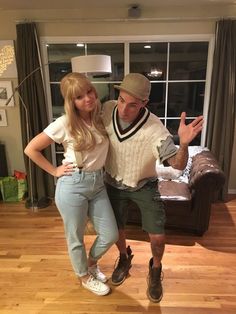 a man and woman posing for a photo in front of a couch