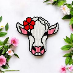 a cross stitch cow with a red bow on it's head is surrounded by pink flowers