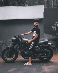 a man sitting on top of a black motorcycle